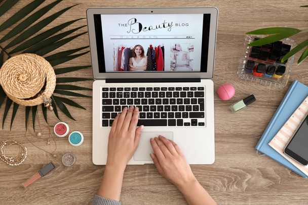 Woman working with beauty blogger site on laptop at table, top view - Photo, Image