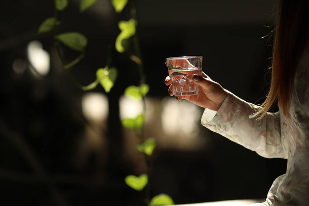 A glass of clean mineral water in woman's hands. Concept of environment protection, healthy drink - Foto, Bild