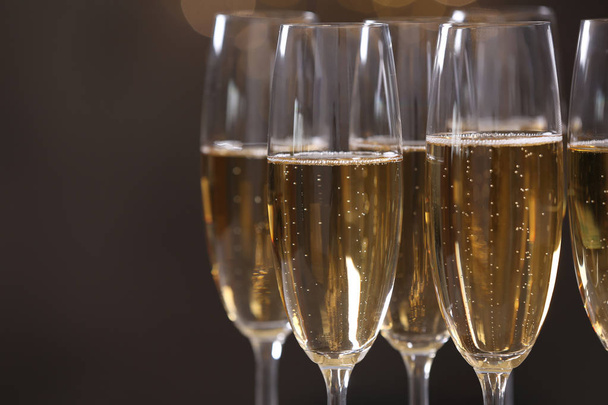 Glasses of champagne on dark background, closeup. Space for text - Foto, Bild