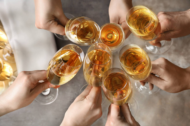 Lidé cinlejí sklenicemi šampaňským přes stůl, pohled shora - Fotografie, Obrázek