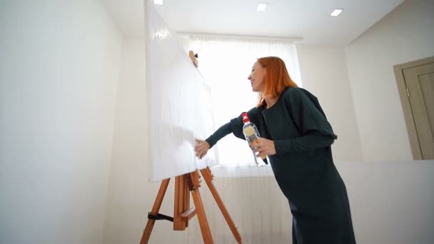 Femme artiste commence à peindre un tableau. Mouillez la toile avec de l'eau et préparez-la pour le dessin
. - Séquence, vidéo