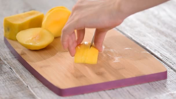 Chefs femeninos cortan mango en tabla de cortar de madera
. - Imágenes, Vídeo