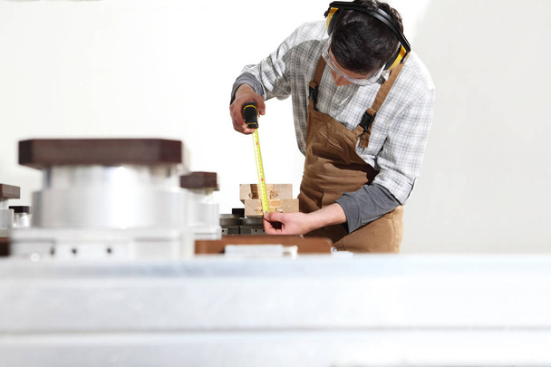 Tesař pracuje s dřevěnými hobulky v jídelně, měří w - Fotografie, Obrázek