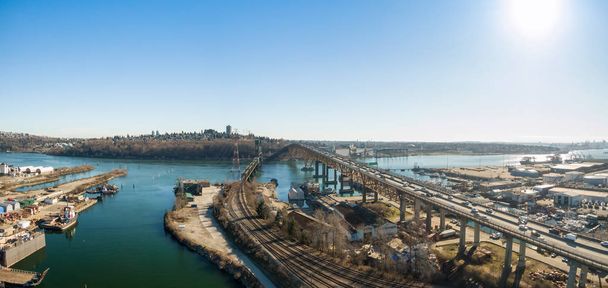 Aerial panoramic view of an Industrial Site and Second Narrows Bridge during a sunny summer day. Taken in North Vancouver, British Columbia, Canada. - Фото, зображення