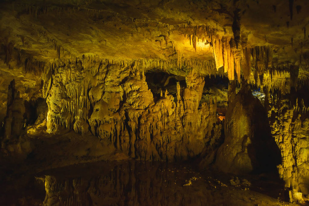 Prometheus Cave in Georgia. Multi-colored illumination of stalagmites and stalactites. Professional Cave Lighting. - Photo, Image