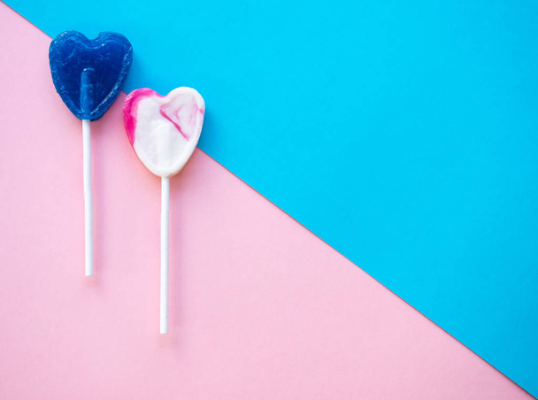 Pink and white and blue lollipops on a pink and blue background - Photo, image