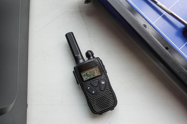 Портативный черный радиопередатчик лежит на столе
 - Фото, изображение