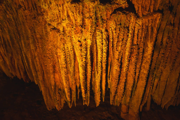 Cueva Prometeo en Georgia. Cueva de estalactita de iluminación multicolor. Iluminación de color de estalactitas en la cueva
. - Foto, imagen