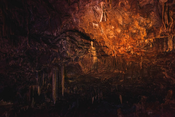 Prometheus Cave in Georgia. Multicolored lighting stalactite cave. Color lighting of stalactites in the cave. - Photo, Image