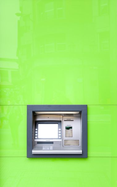 Máquina ATM na parede verde brilhando ao sol
. - Foto, Imagem