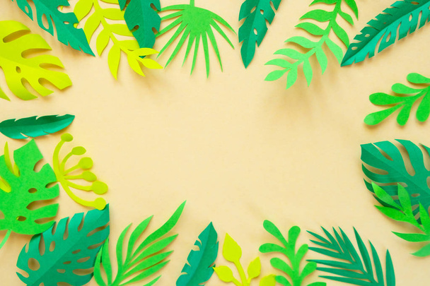tropical leaves cut from paper on a yellow background. - Фото, зображення