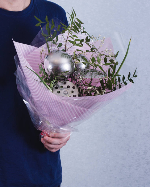 A man hold bouquet of flowers and ladles. concept of sexism, fem - Фото, зображення