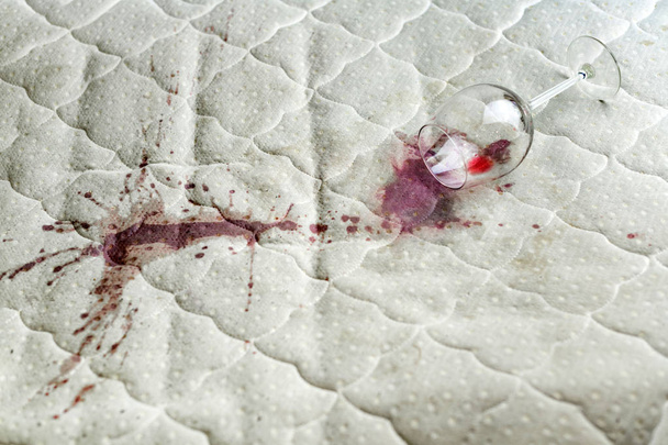 Wine glass spilled on bed. Dropped wineglass on white bed sheet. - Fotoğraf, Görsel