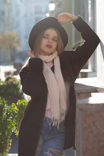 Street shot of glamor girl wearing hat and scarf, enjoying warm  - Zdjęcie, obraz