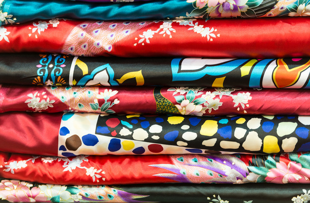 Pile of silk clothes with abstract asian design. - Photo, Image