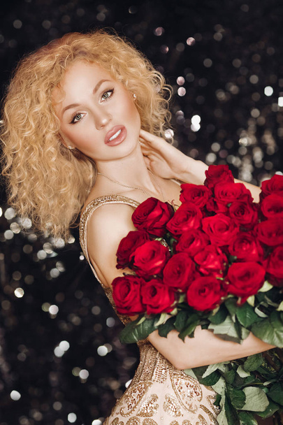 Τέλεια εκπληκτική κυρία με μπουκέτο κόκκινα τριαντάφυλλα. - Φωτογραφία, εικόνα