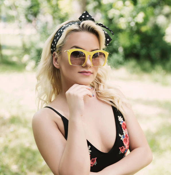 Portrait of young woman in sunglasses outdoors - Photo, Image