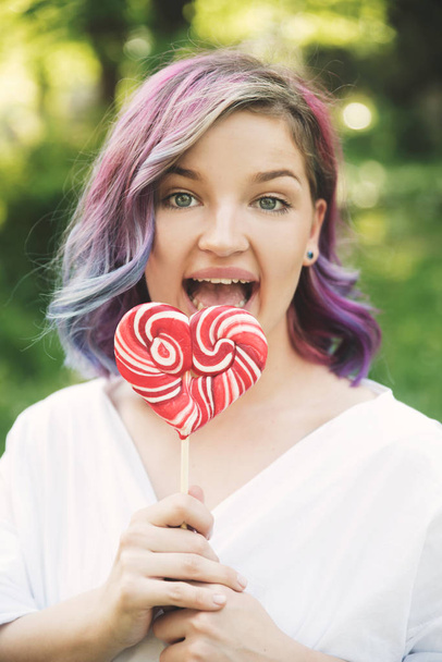 Young woman with dyed hair and lollipop - Фото, зображення