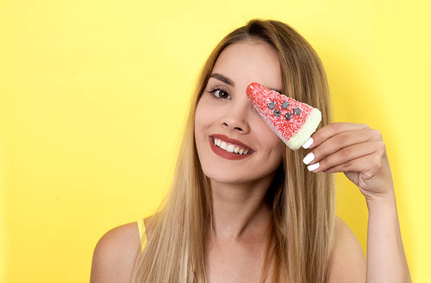 Young woman posing with ice cream on yellow background - 写真・画像