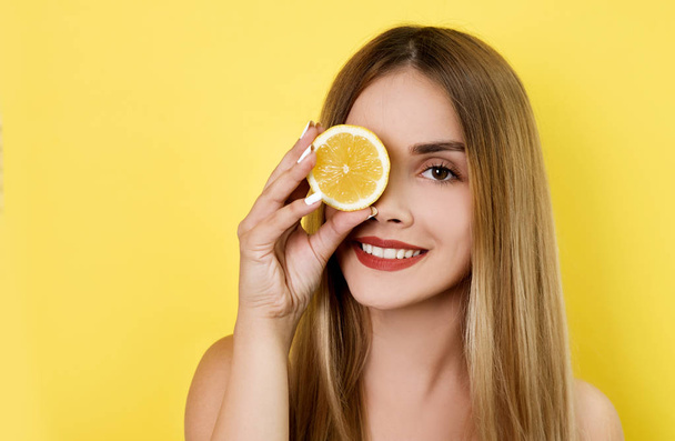 Young woman posing with lemon slice - 写真・画像