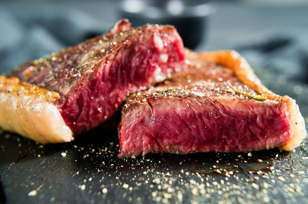 Steak z hovězí svíčkové, pečené vzadu. Černé pozadí, pohled shora. - Fotografie, Obrázek