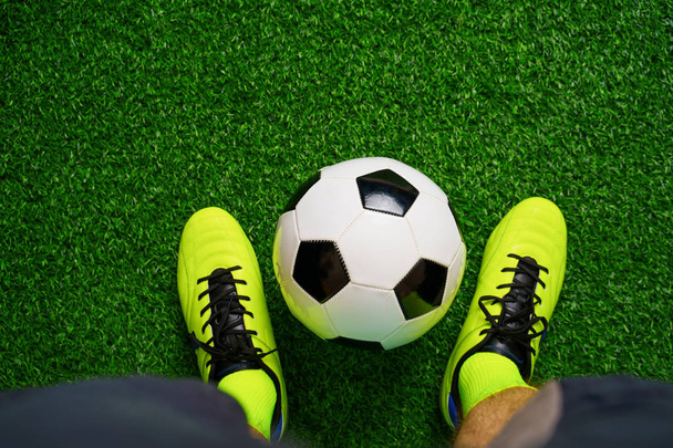 Soccer shoes and football on the green grass - Photo, Image