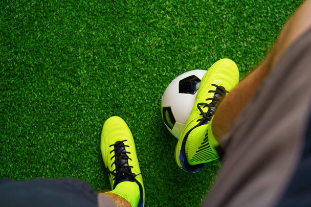 Soccer shoes and football on the green grass - Photo, Image