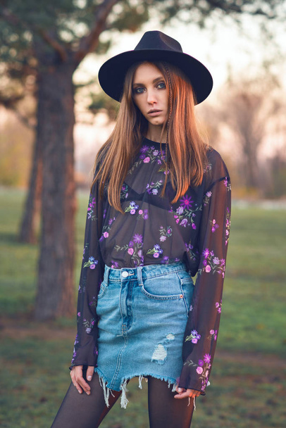 Beautiful girl in a denim skirt and a transparent blouse. - Foto, Imagen