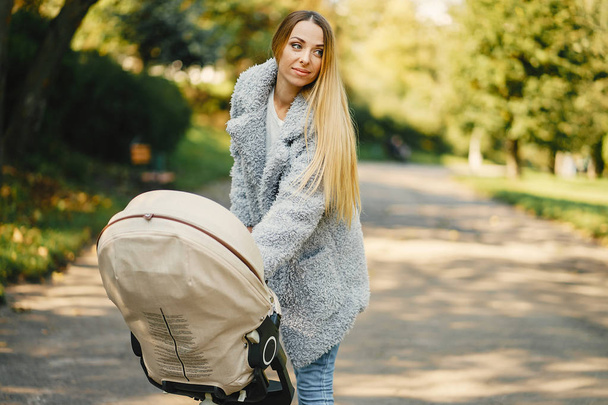 young mother pushing a stroller - Foto, afbeelding
