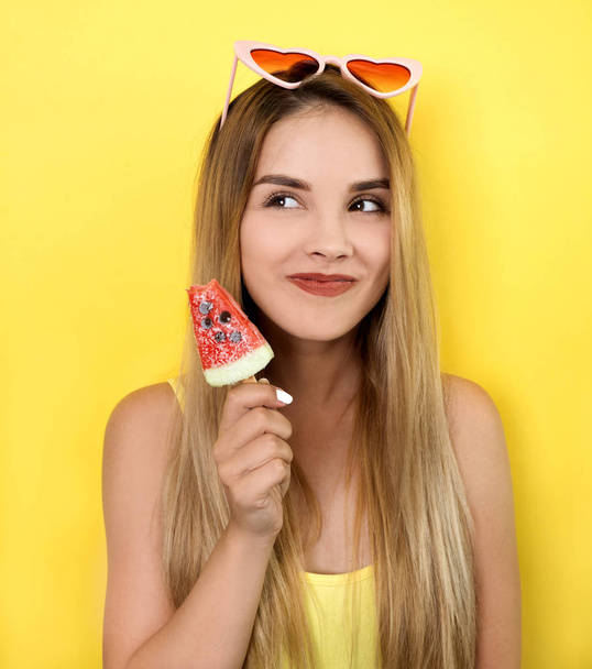 Young woman posing with ice cream on yellow background - Foto, Imagen