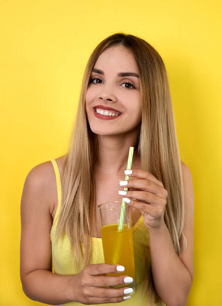 Young woman posing with cocktail on bright background - Foto, Imagen