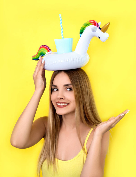 Nuori nainen poseeraa cocktailin kanssa kirkkaalla taustalla
 - Valokuva, kuva