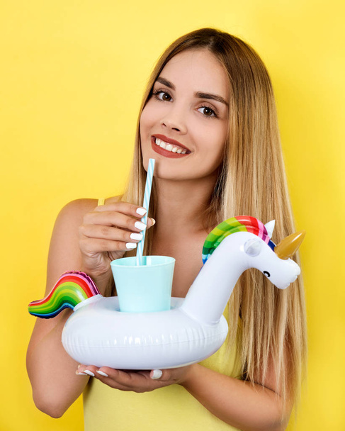 Young woman posing with cocktail on bright background - Photo, Image