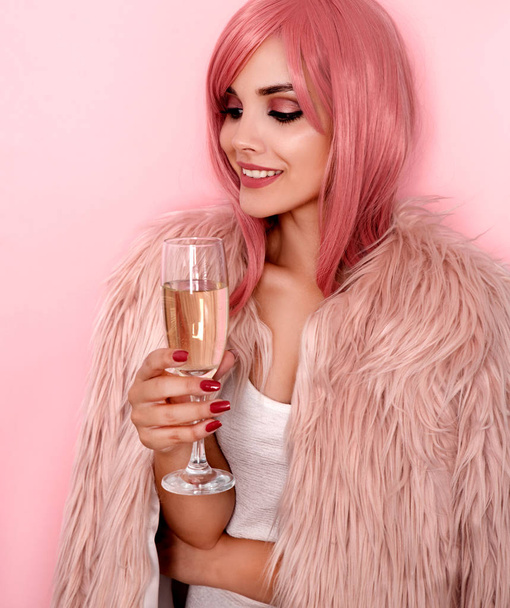 Young woman in fur coat holding glass of champagne - Photo, Image