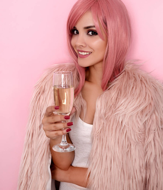 Young woman in fur coat holding glass of champagne - Foto, immagini