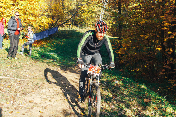 October 14, 2018, Minsk, Belarus.2018 Olympic Cross Country Cup XCO in Medvezhino Cyclist on the bike along the trail in the beautiful autumn forest - Фото, изображение