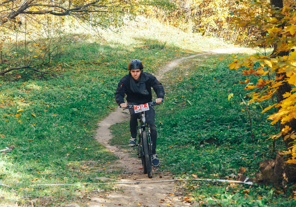 10月14, 2018,ミンスク,ベラルーシ. 2018オリンピッククロスカントリーカップXCO Medvezhino Cyclist美しい秋の森の中の歩道に沿って自転車に乗って - 写真・画像