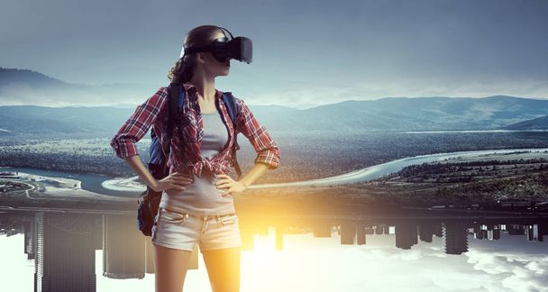 Travelling female tourist with backpack and VR helmet - Foto, imagen