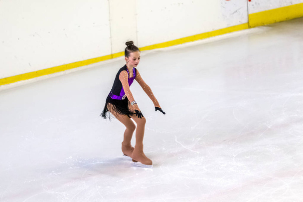 ODESSA, UKRAINE -11 Apr 2019: Young children figure skating on ice arena of stadium. Little girls learn to skate. School of figure skating. Young figure skaters train at indoor rink. Young sport girls - Фото, изображение
