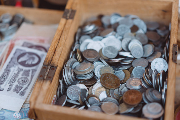 Monedas antiguas de diferentes denominaciones están en una pequeña caja de madera
 - Foto, imagen
