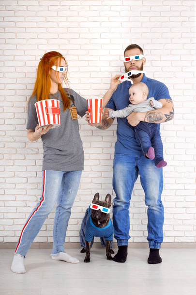 Νεαρή οικογένεια με μικρά παιδιά και σκύλο με τρισδιάστατα γυαλιά. κινηματογράφος - Φωτογραφία, εικόνα
