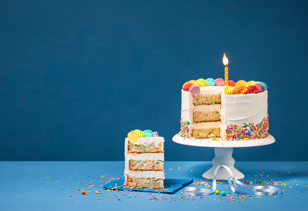 Colorful Birthday Cake with Slice and Sprinkles - Foto, afbeelding