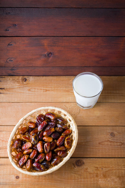 Dried dates and milk on wooden background. Holy month of Ramadan, concept. Righteous Muslim lifestyle. Starvation. Dates in a wooden basket in the style of minimalism. Copy space - Valokuva, kuva