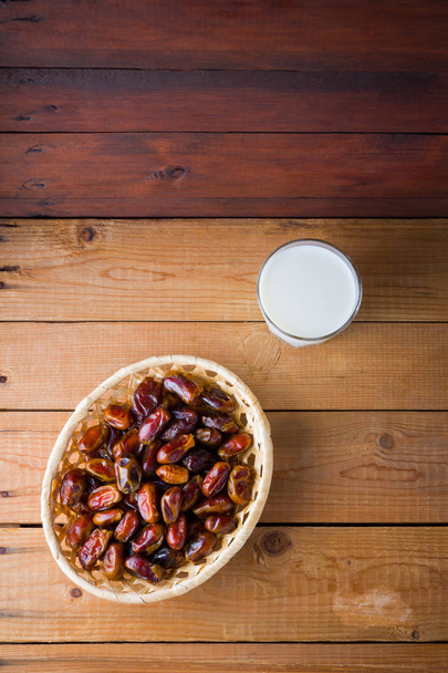 Dried dates and milk on wooden background. Holy month of Ramadan, concept. Righteous Muslim lifestyle. Starvation. Dates in a wooden basket in the style of minimalism. Copy space - Valokuva, kuva