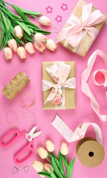 Gifts wrapped in kraft paper and pink ribbons overhead flatlay. - Photo, Image