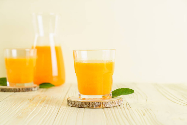 Fresh orange juice on wood background - Foto, afbeelding