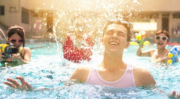 Щасливі друзі грають у басейні на літніх канікулах
 - Фото, зображення