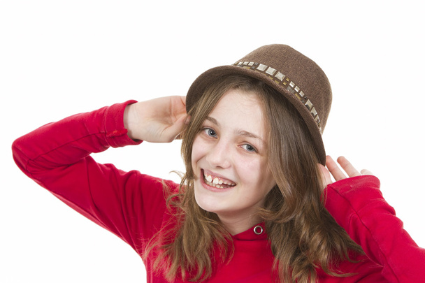 junges Mädchen lächelt und setzt ihren Hut auf - Foto, Bild