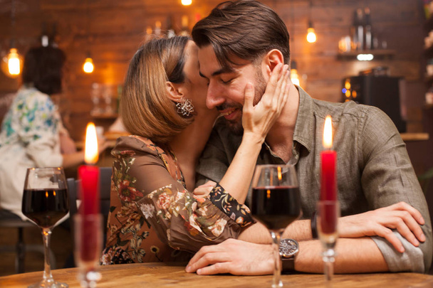 Bonita pareja joven haciéndose reír en un restaurante vintage
 - Foto, Imagen