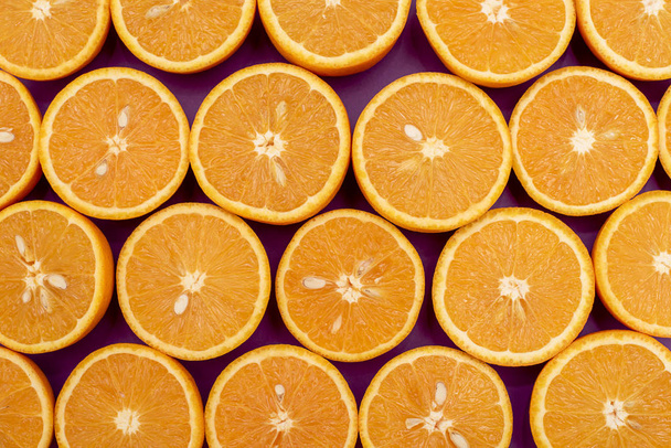 Πορτοκαλί νόστιμα πορτοκάλια Σπλιτ στο μισό βρίσκεται σε μια σειρά στο μωβ - Φωτογραφία, εικόνα
